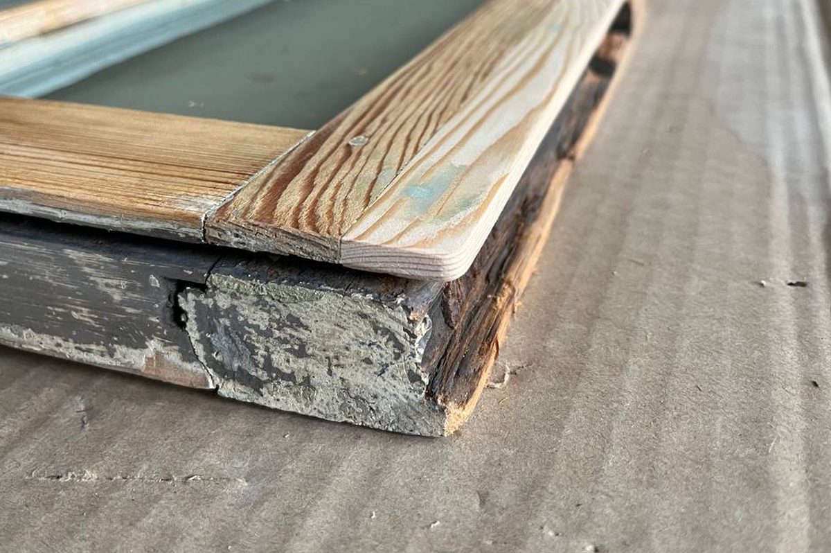 Close-up of a timber window frame being repaired and re-puttied